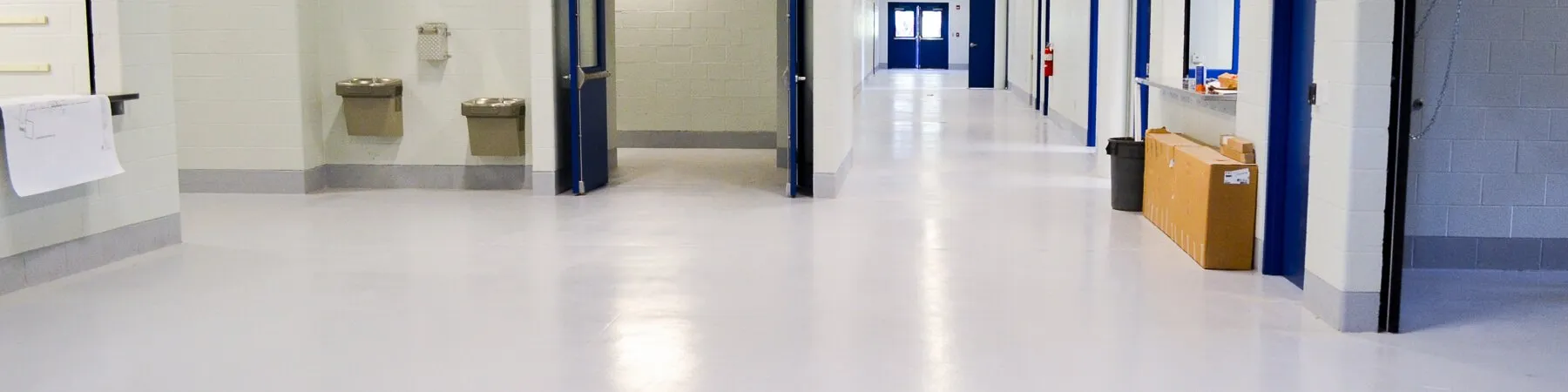 Long school hallway with a glossy, light gray epoxy-coated floor — cover image for the Coatings for Industry website project