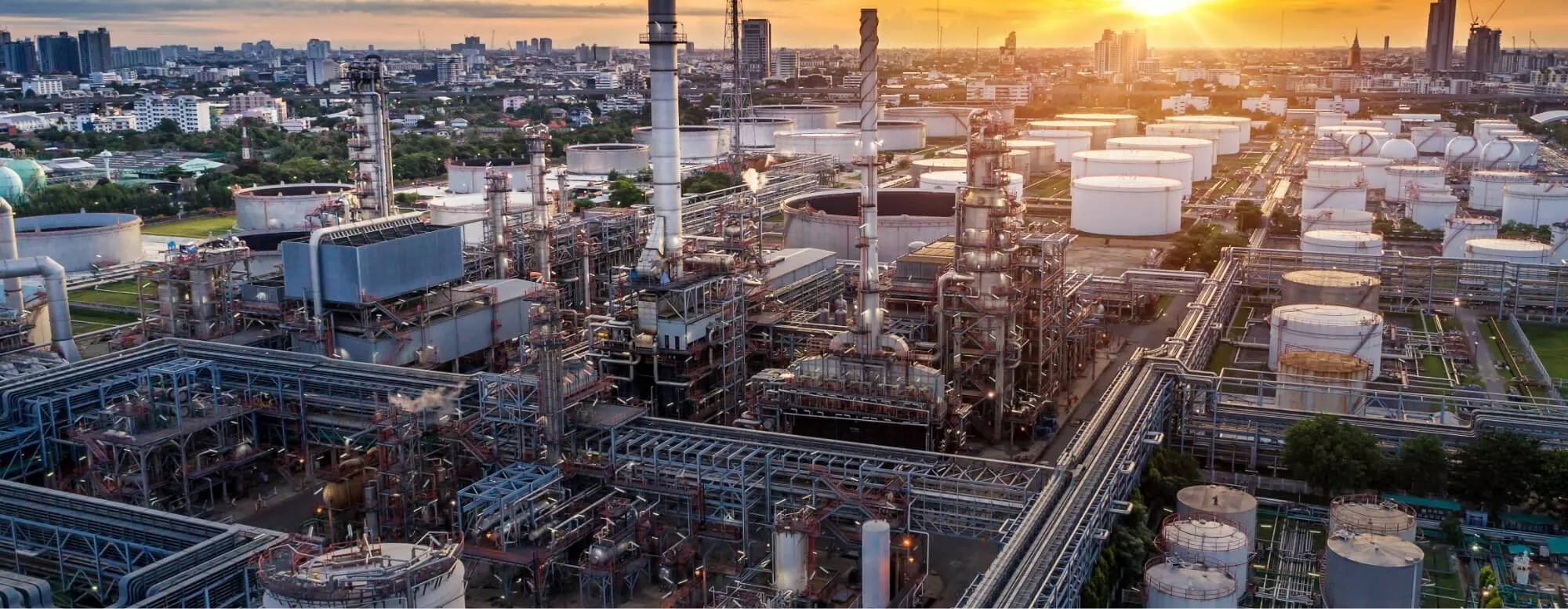 Aerial view of an industrial refinery and storage tanks at sunset