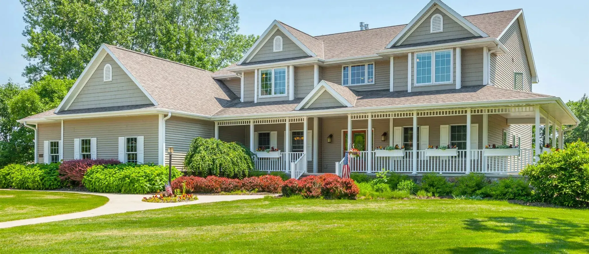 Two-story suburban home with a wraparound front porch, flowering shrubs, and a manicured lawn — cover image for the Delaware Valley Septics website project
